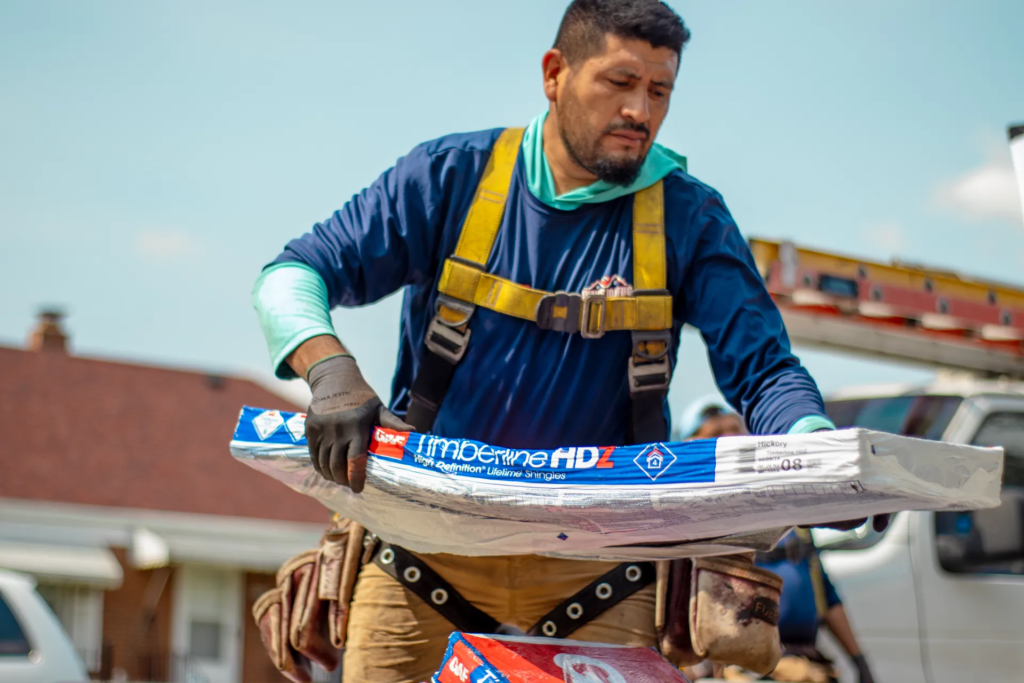 roofer carrying GAF HDZ shingles