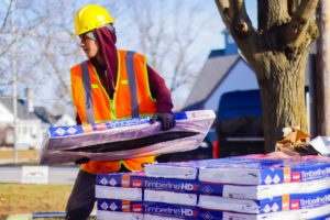 worker stacking GAF Timberline shingles