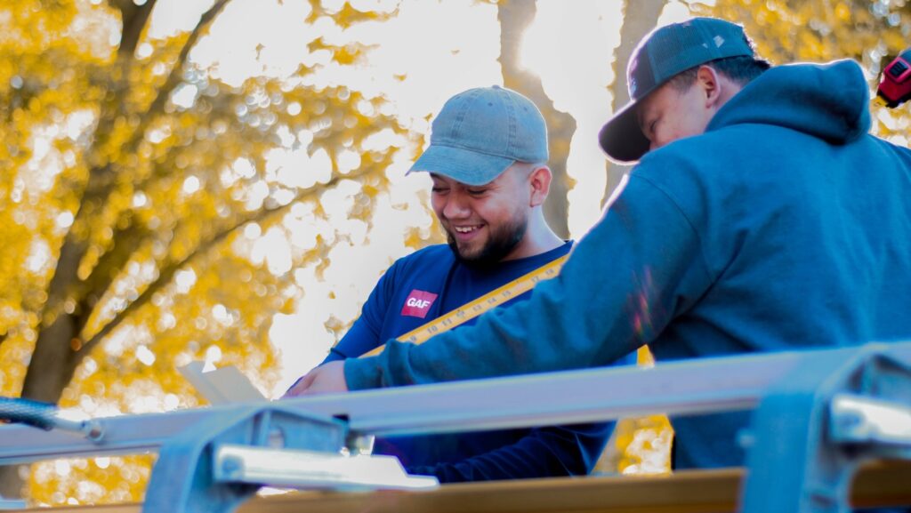 GAF roofers measuring smiling