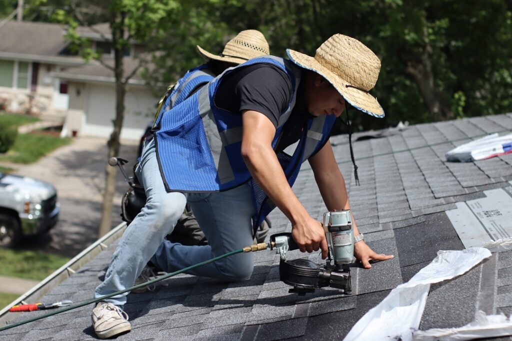 roofer nailing shingles rooftop