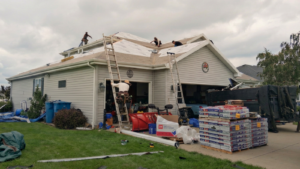 Professional roof tear off and replacement project showing old shingles being removed and a new roofing system installed on a residential home